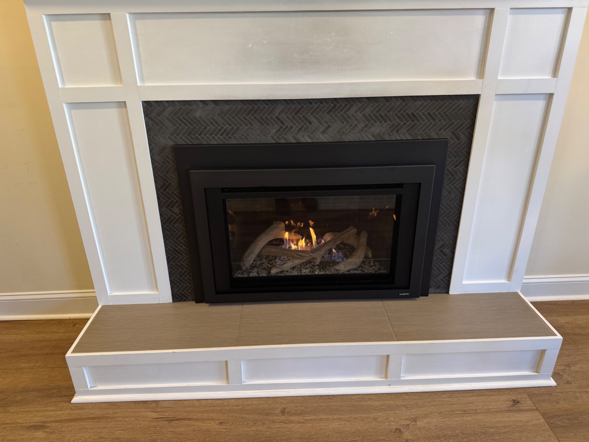 Majestic Ruby 30 inch gas insert with reflective black glass, driftwood logs, and glass media